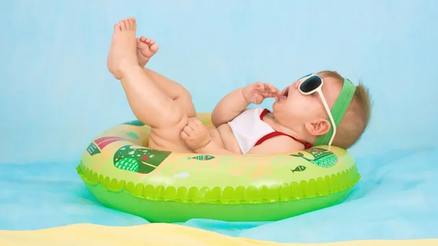 Baby met zonnebril relaxt in een groene zwemband