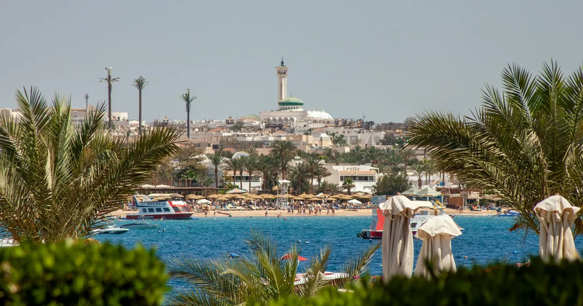 Moskee en strand van Hurghada gezien door palmbladeren