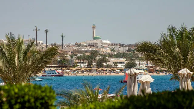 Moskee en strand van Hurghada gezien door palmbladeren