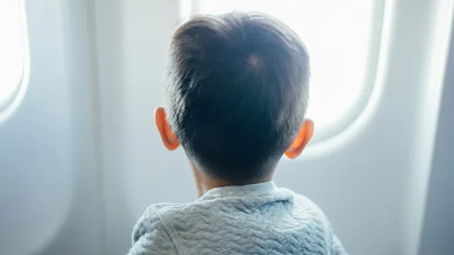Jongetje kijkt door het raam van een vliegtuig naar buiten