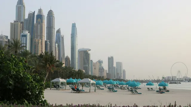 Strand van Dubai met wolkenkrabbers aan de horizon in het late licht