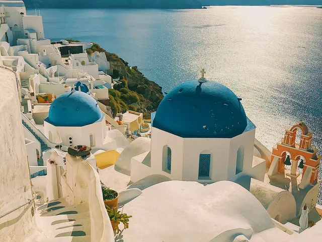 Witte huizen en blauwe koepels van Oia op Santorini met zeezicht