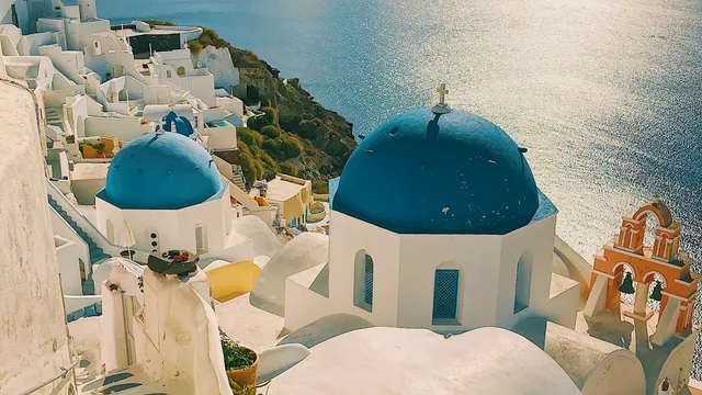 Witte huizen en blauwe koepels van Santorini boven de zee