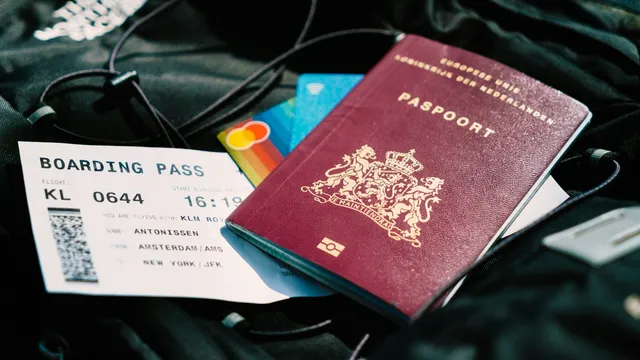 Nederlands paspoort met instapkaart en bankpassen op een reistas
