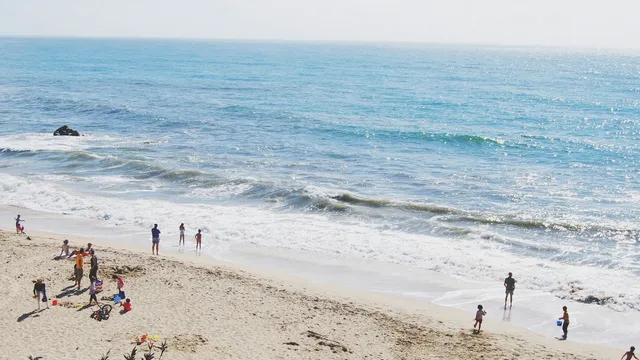 Gezinnen op een zonnig zandstrand aan zee