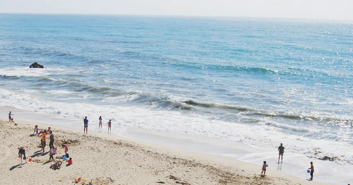 Gezinnen op een zonnig zandstrand aan zee