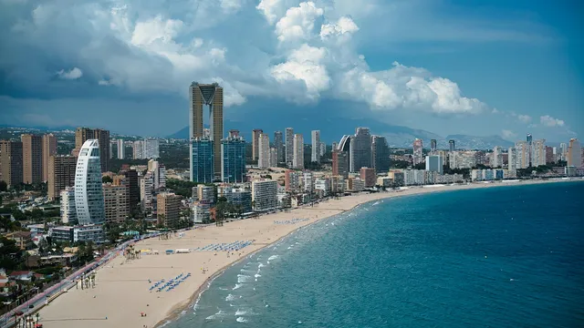 De skyline en het brede zandstrand van Benidorm aan een blauwe baai