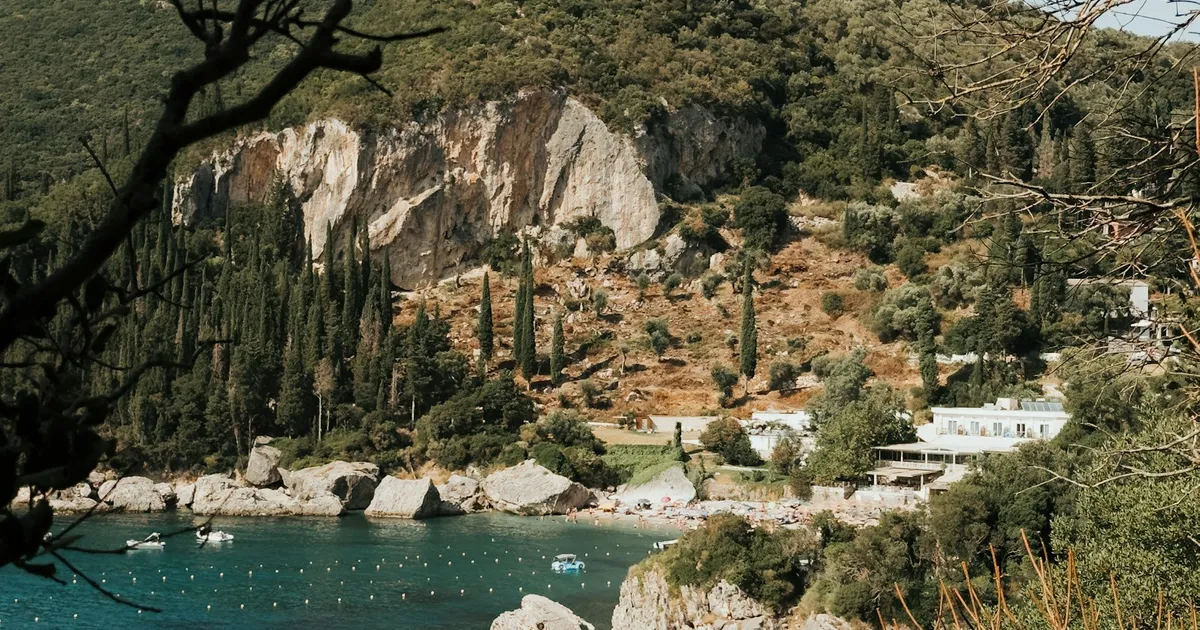Turquoise baai met kliffen, cipressen en een strandje op Corfu