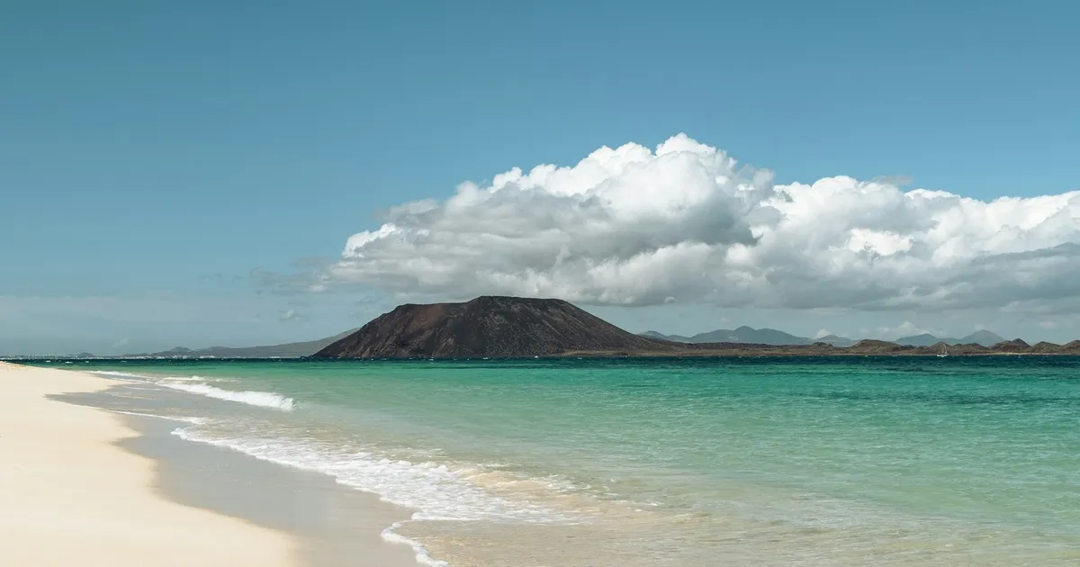 Wit strand met turquoise zee en het eiland Lobos bij Corralejo