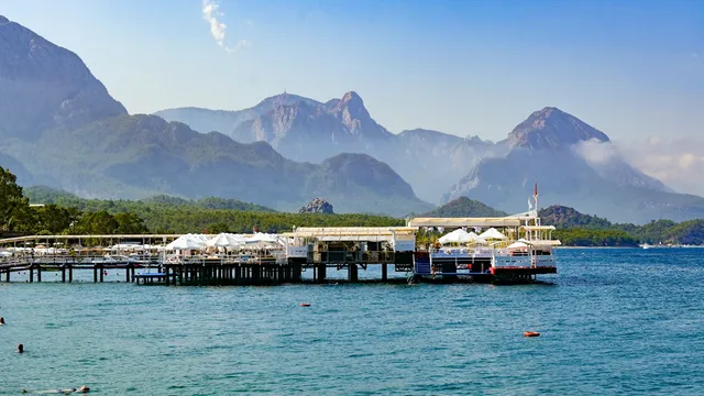 Pier met parasols aan zee bij Kemer met het Taurusgebergte als decor
