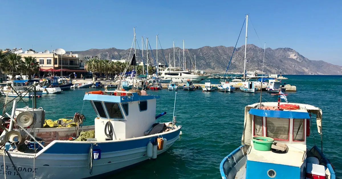 Vissersboten in een haven op Kos met bergen aan de overkant