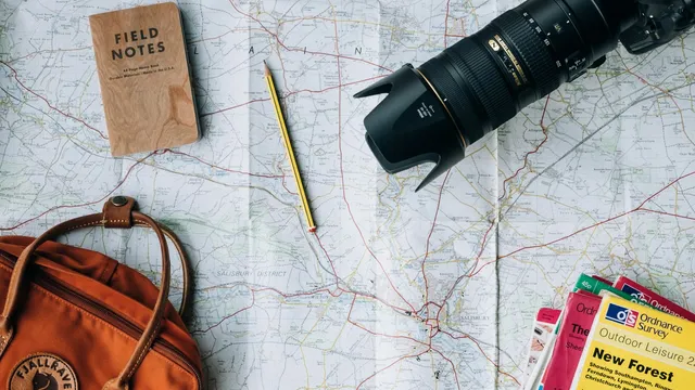 Reiskaart met camera, notitieboekje en rugzak als voorbereiding op vakantie