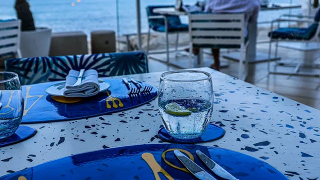 Gedekte restauranttafel met waterglas en uitzicht op zee