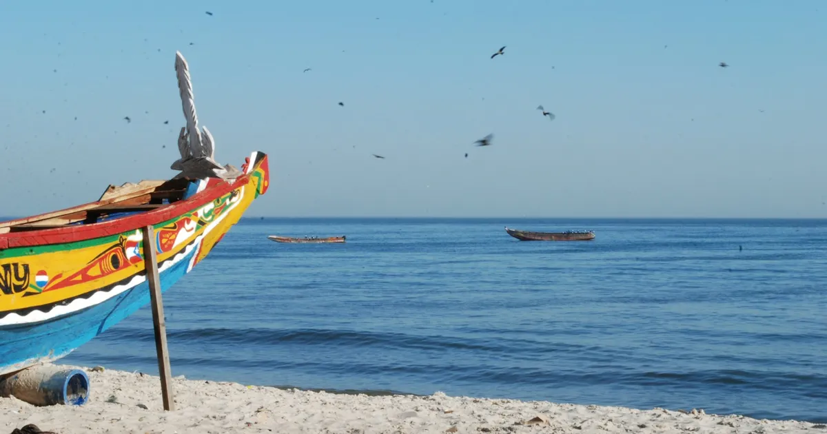 Kleurrijk beschilderde pirogue op het strand aan de kust van Senegal