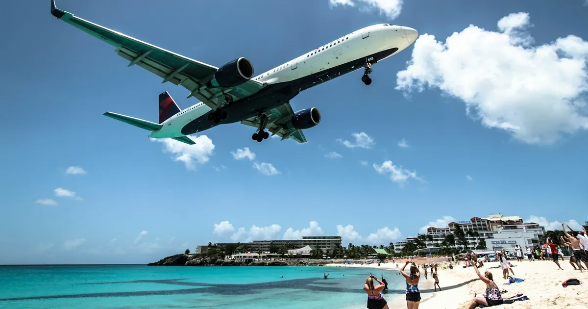 Vliegtuig scheert laag over het strand van Maho Beach op Sint Maarten