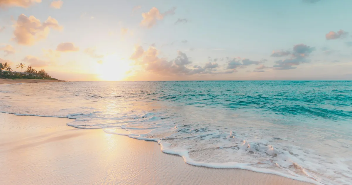 Zonsondergang op een tropisch strand met kalme zee