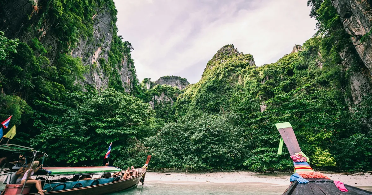 Longtailboten in een baai met kalkrotsen bij Koh Phi Phi