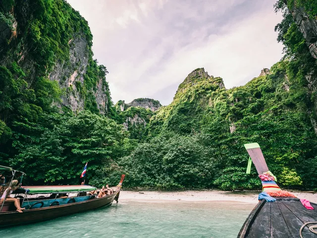 Longtailboten in een baai met kalkrotsen bij Koh Phi Phi