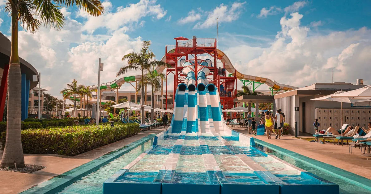 Waterpark met glijbanen en palmbomen in een zonnig resort