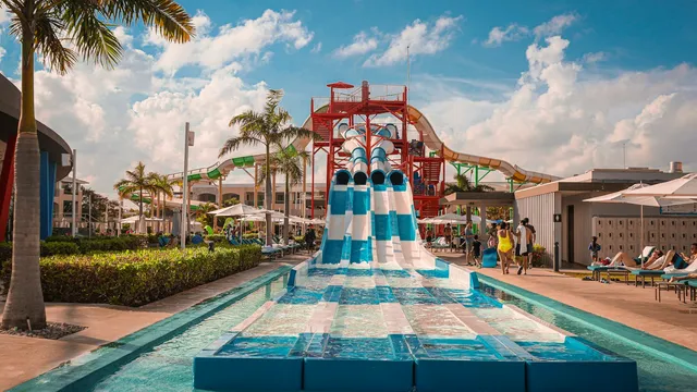 Waterpark met glijbanen en palmbomen in een zonnig resort